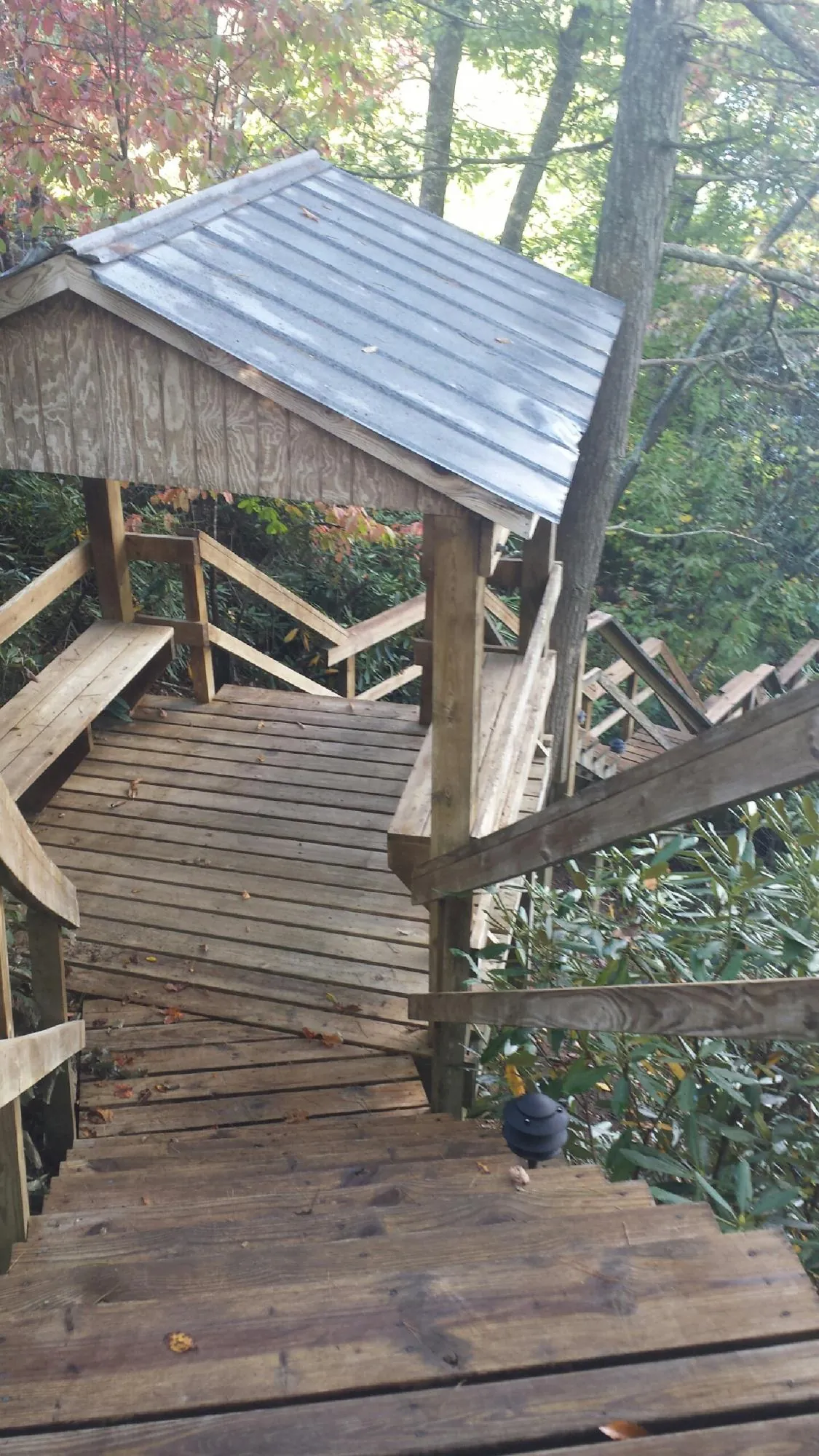 Metal roofed shelter over wooden steps on a wooded walkway — Skylight Repair & Installation work by our crew in Pontiac