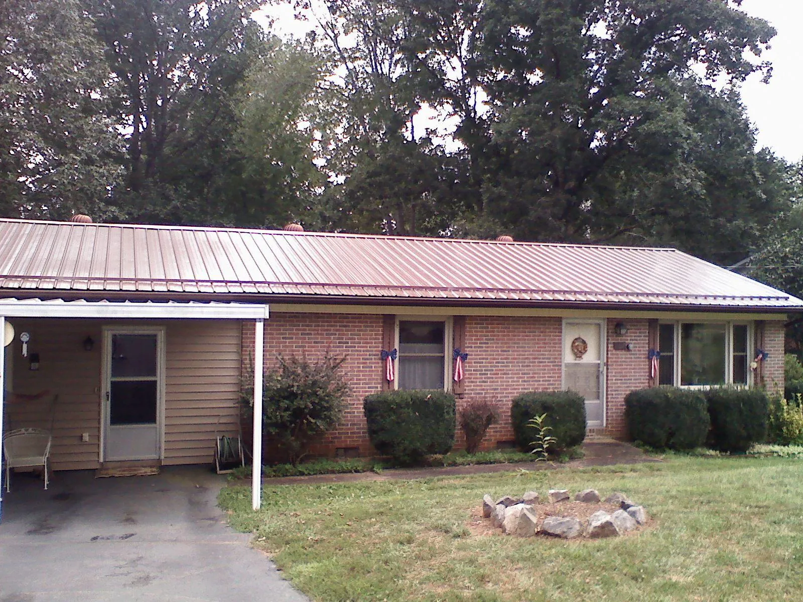 Bronze metal roof and carport on a brick ranch home — Roof Repair work by our crew in Pontiac
