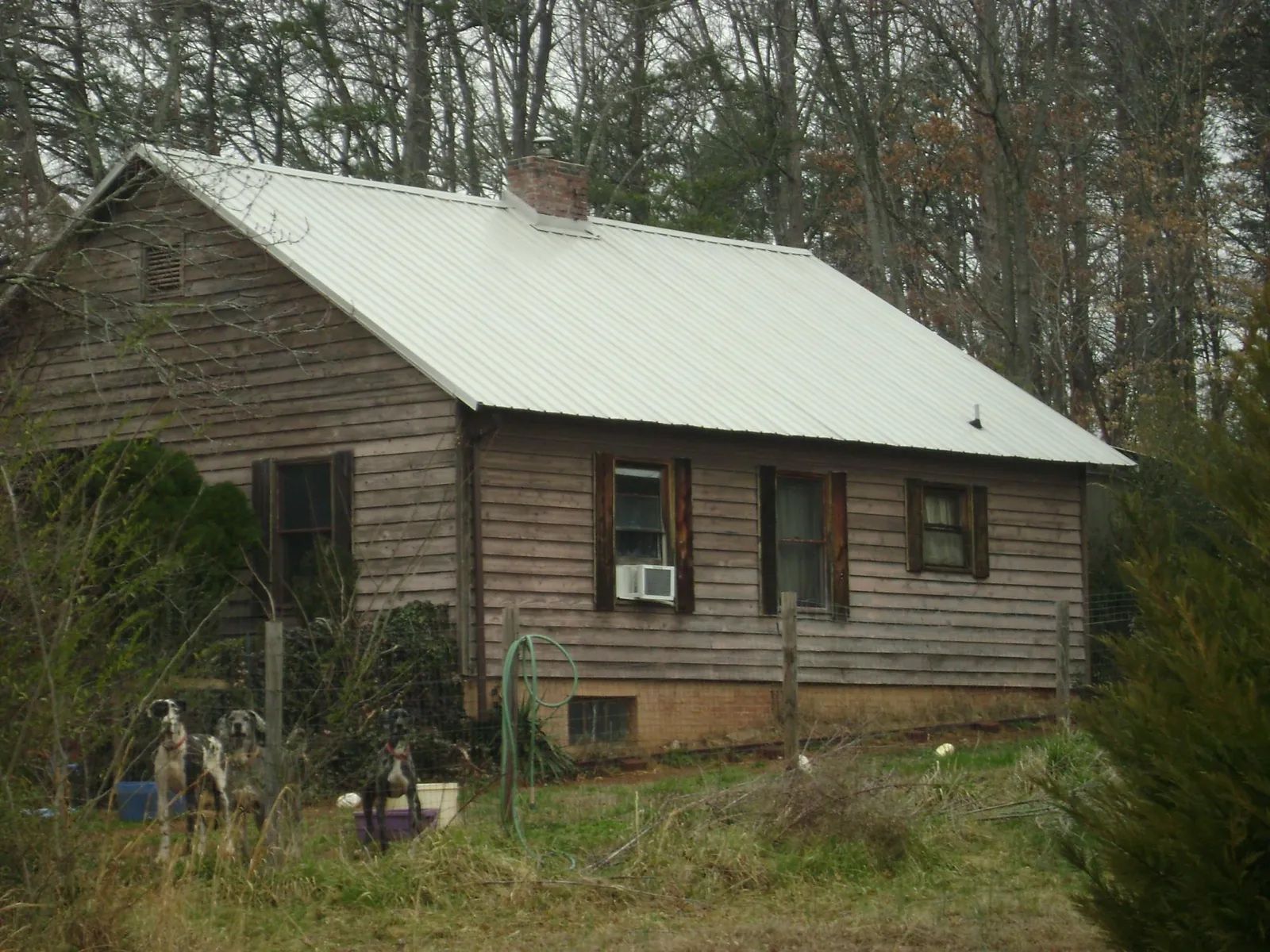 White metal roof on an old wood sided farmhouse, from a Metal Roof Installation job in Pontiac